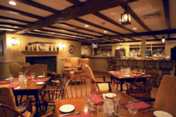 beamed ceiling in old tavern room with wooden tables and Windsor chairs